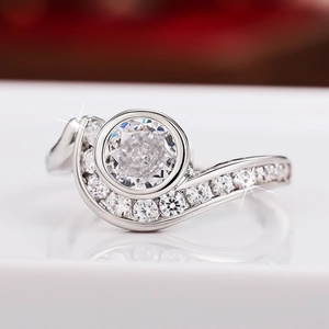 Vista macro de anillo de plata irregular con diamante redondo y piedras laterales