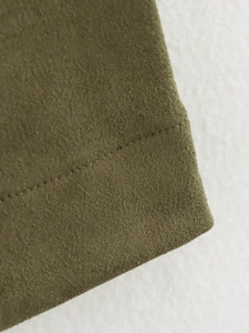Close-up of olive green suede fabric texture and professional stitching on the skirt