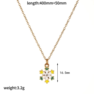 Detailed view of gold snowflake necklace with white enamel and product dimensions