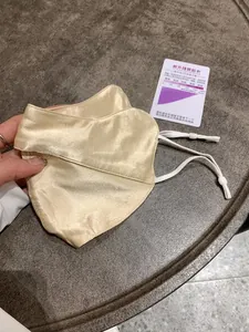 Detail of silk face mask with UV detection sticker and adjustable white ear loops