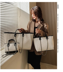 Detailed comparison of three sizes of canvas bucket bags with black leather trim and chain