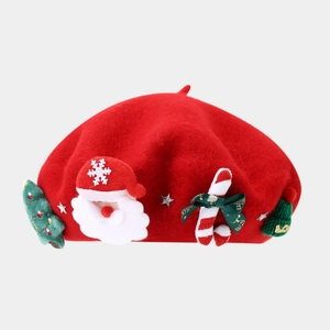 Close-up of red wool beret with Santa Claus embroidery and green Merry bow decoration