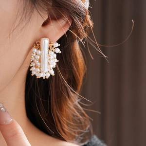 Détail des boucles d'oreilles vintage françaises avec perles et base en métal doré