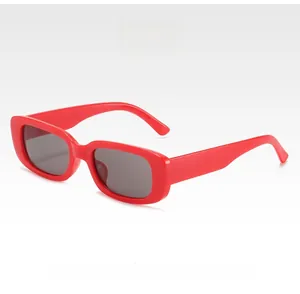 Detailed close-up of retro red rectangular sunglasses with dark gray fashion lenses