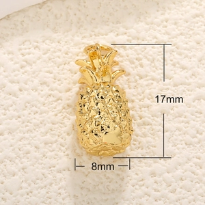Dettaglio ravvicinato di un ciondolo a forma di ananas dorato con misure 17mm per 8mm