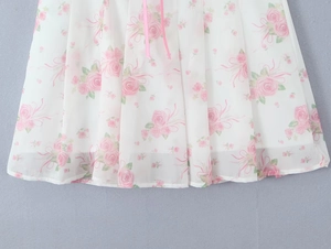 Detailed view of floral chiffon dress with pink rose patterns and delicate silk ribbons