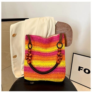 Detail of colorful woven straw bag with dark wooden beads and rainbow stripes on handle