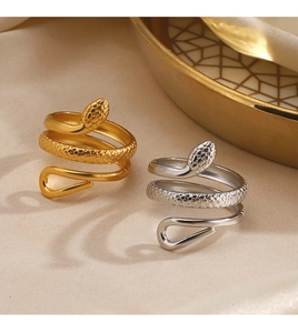 Macro detail of gold and silver snake rings with intricate scale textures on silk