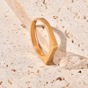 Detail of 18K gold geometric V-ring with pavé rhinestones on polished titanium steel