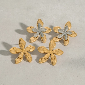 Detail of flower stud earrings featuring metallic petals and textured hammered finish
