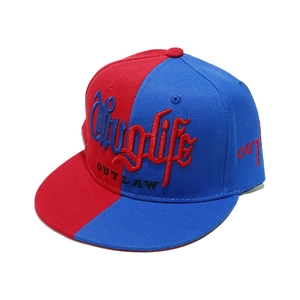 Detail der 3D-Stickerei Thug Life und Outlaw auf einer rot-blauen Flat-Brim-Snapback-Cap