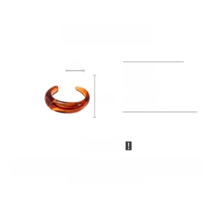 Detail view of amber acrylic bangle showing dimensions 8cm by 6.5cm and marble texture