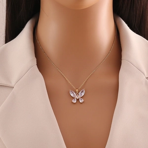 Elegant gold butterfly pendant necklace with white gemstones on a professional model