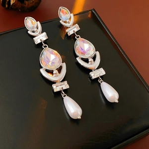 Macro shot of silver drop earrings featuring crystal rhinestones and water-drop pearls