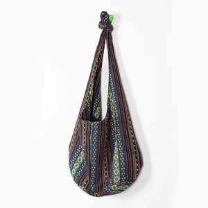 Detail of bohemian knit hobo bag with colorful geometric patterns and knotted strap