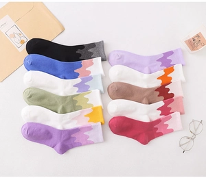 Flat lay of cotton crew socks in ten gradient colors with creative stitching designs