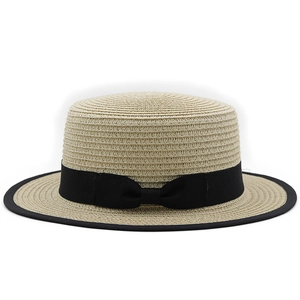 Detail showing the exquisite black piping edge and ribbon bow on a beige straw boater hat
