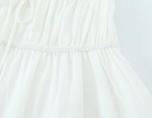 Détail d'une robe d'été blanche avec taille élastique plissée et texture de tissu léger