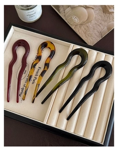 Détail de quatre épingles en U ondulées en résine bordeaux, écaille, olive et noire