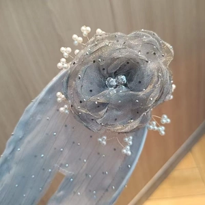 Close-up of grey tulle flower bun maker with sparkling rhinestones and pearl details