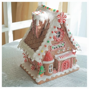 Close-up of a Christmas gingerbread house ornament with candy decor and warm LED light