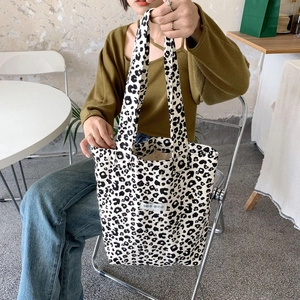 Close-up of leopard print canvas tote bag with a minimalist decorative tag
