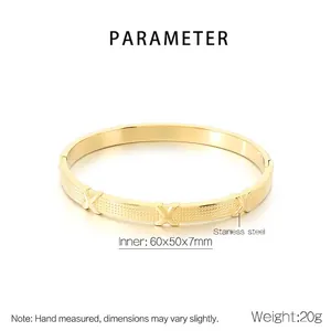 Detailed macro view of gold-plated stainless steel bangle with X-shaped relief pattern