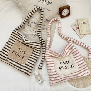 Détail de sacs fourre-tout en peluche rayée avec poches brodées 'FUN PIACE'