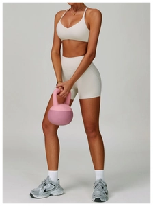 Detail view of the backless yoga set featuring a cream halter top and high-waisted shorts