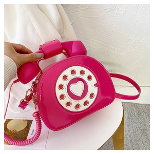 Detailed view of the creative rotary phone crossbody bag with pink patent leather finish