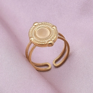 Close-up of golden stainless steel open ring with round sunburst engraved badge detail