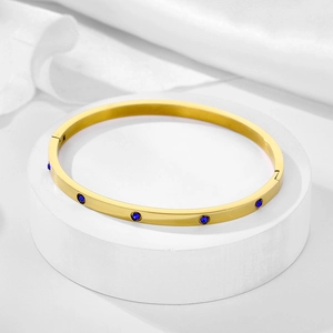 Detailed macro view of 4mm gold plated stainless steel bracelet with blue zircon inlay