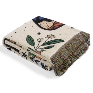 Macro detail of bohemian woven camping blanket with bird motifs and colorful fringes