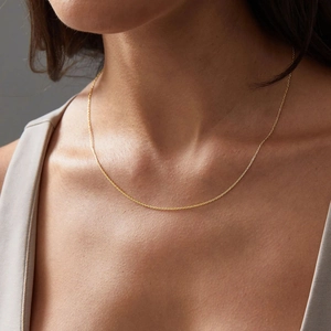 Minimalist 14K gold plated stainless steel cable chain necklace shown on a female model