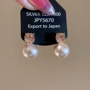 Pink gemstone and white pearl 925 silver earrings set on black display card