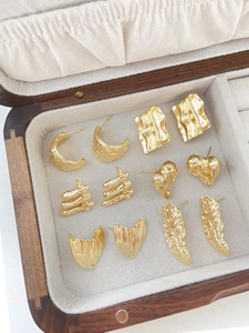 Macro shot of gold-plated heart and square earrings in various vintage textured designs