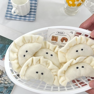 Cute white dumpling plush keychain charms in a basket for bags and accessories