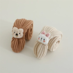 Detail of knitted baby scarves featuring 3D plush bear and rabbit animal patterns