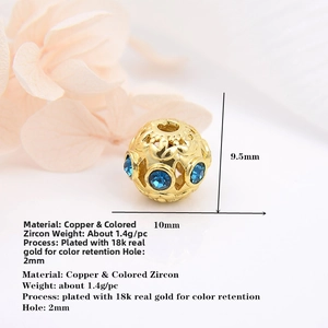 Macro shot of 10mm hollow 18k gold plated bead featuring blue zircon and floral patterns