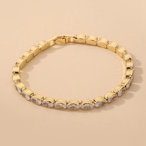 Close-up of gold geometric tennis bracelet with oval cubic zirconia and folding clasp