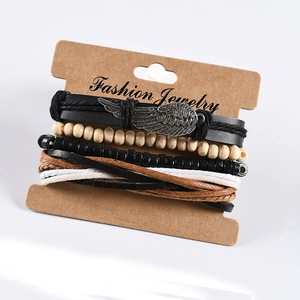 Detail of multi-layer leather bracelet set with wing charm and wooden beads on card