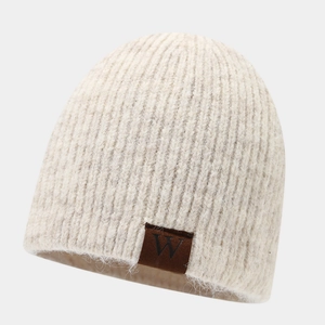 Detail of knit beanie texture with vertical stripe pattern and brown leather W patch