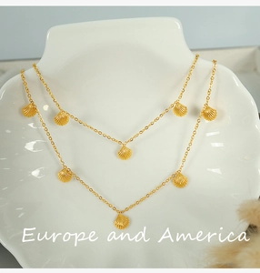 Close-up of golden shell pendant necklace on white mannequin bust with delicate details