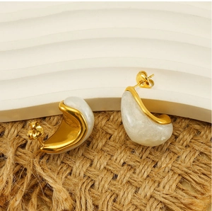 Détail des boucles d'oreilles en acier inoxydable doré avec résine effet marbre blanc