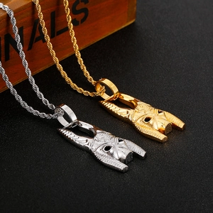 Detailed view of 18K gold and silver horn pendants with twisted rope chains on black