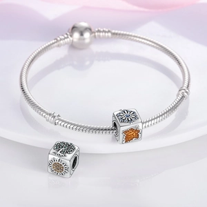 Vue macro de breloques flocon de neige et arbre de vie sur un bracelet à maille serpent