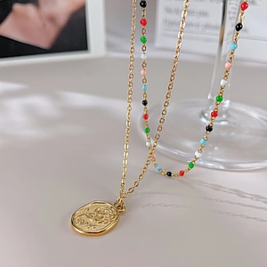 Détail du collier double rang en acier inoxydable avec perles et pendentif rose