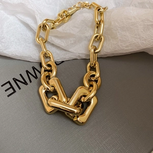 Detail of chunky gold chain necklace with polished rectangular and round metal links