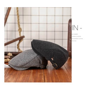 Detail of wool fabric texture and adjustable metal buckles on vintage newsboy caps