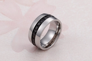 Close-up of a wide silver band ring with embedded black geometric cubic zirconia stones